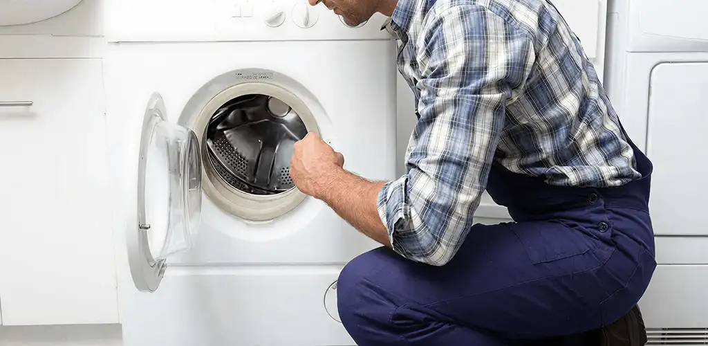 Handyman inspecting a dryer drum and internal parts for repair in Dover, DE