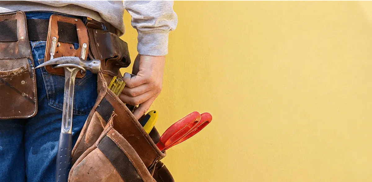 Handyman with tool belt ready for home repairs and maintenance in Dover, DE