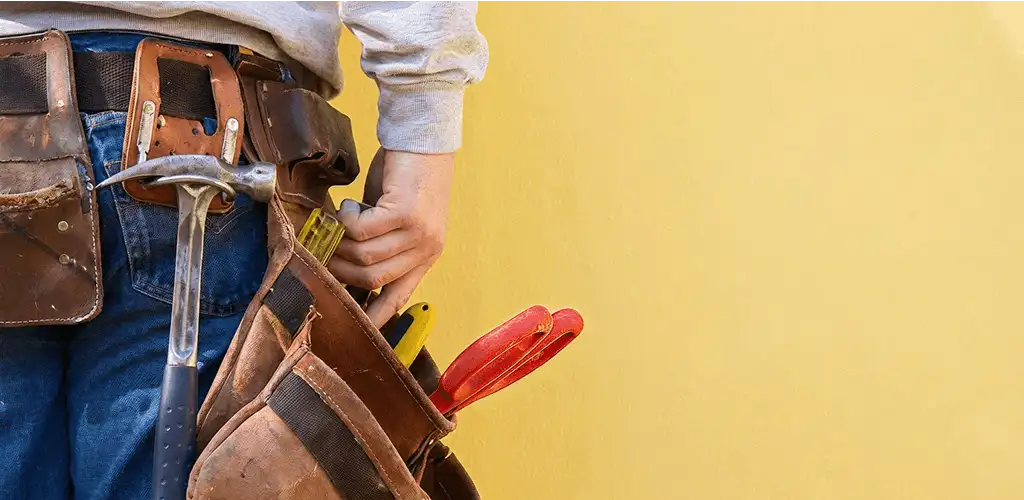 Handyman with tool belt ready for home repairs and maintenance in Dover, DE