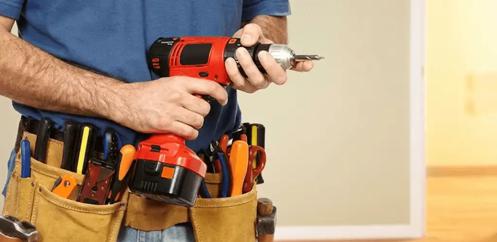 Handyman holding a power drill for home repairs and installations in Dover, DE